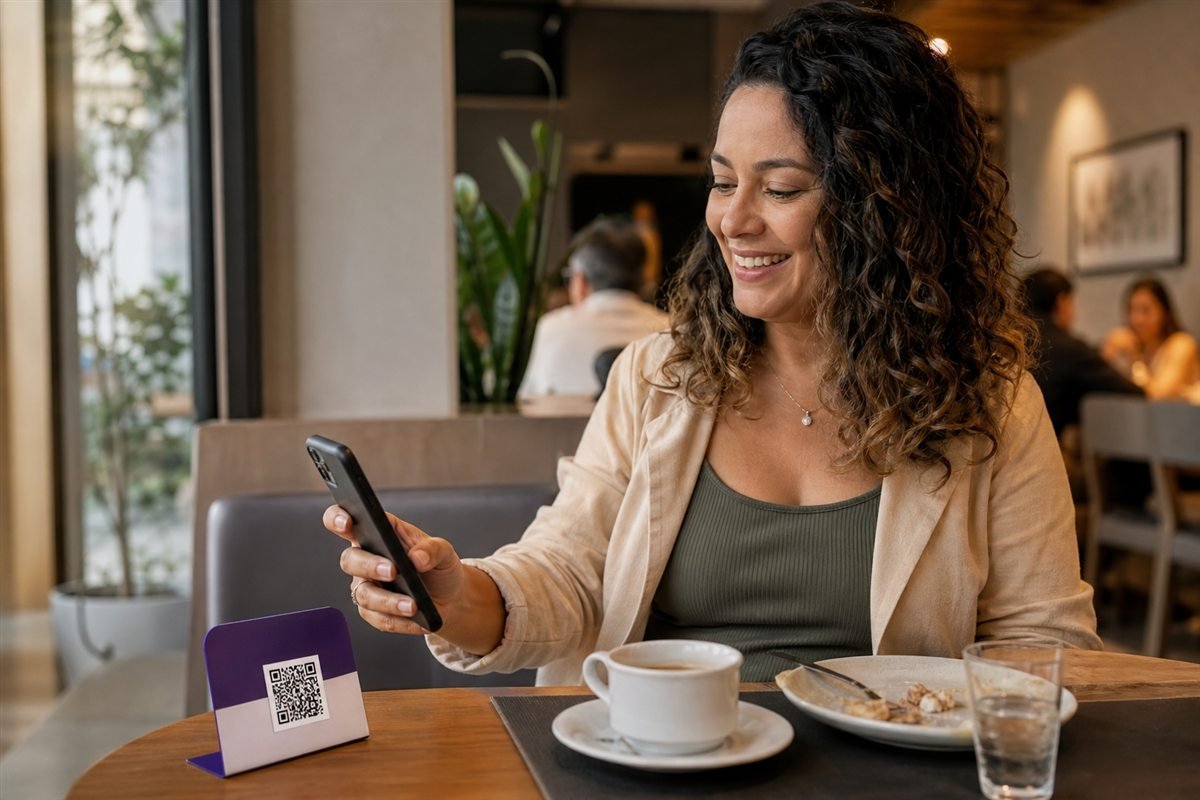 Cliente usando o celular para ler um QR Code em um restaurante